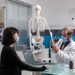 doctor ortoped explicand unei paciente beneficiile practicarii kinetoterapiei si fizioterapiei