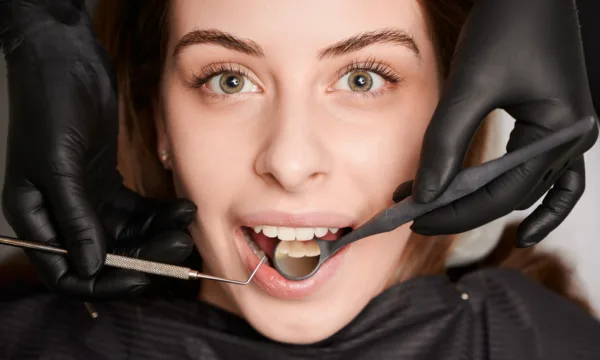 femeie privind camera in timpul unui consult stomatologic