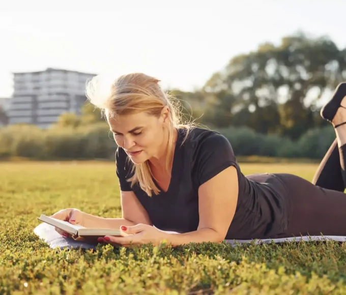 femeie matura sportiva citind o carte in natura