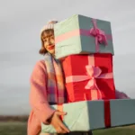 femeie care tine in mana cateva cadouri frumos ambalate