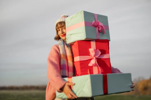 femeie care tine in mana cateva cadouri frumos ambalate
